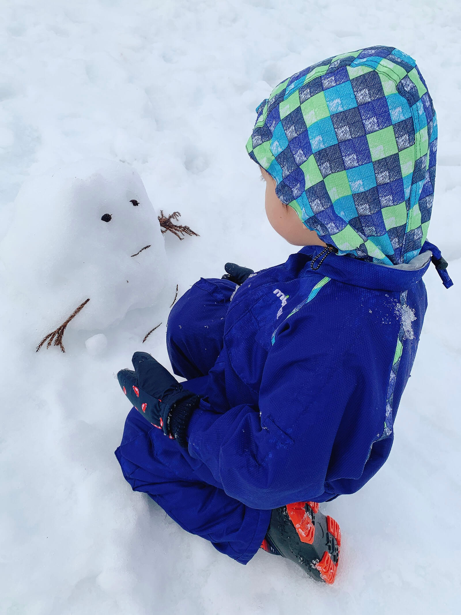 ゲレンデの雪で遊ぶ子ども