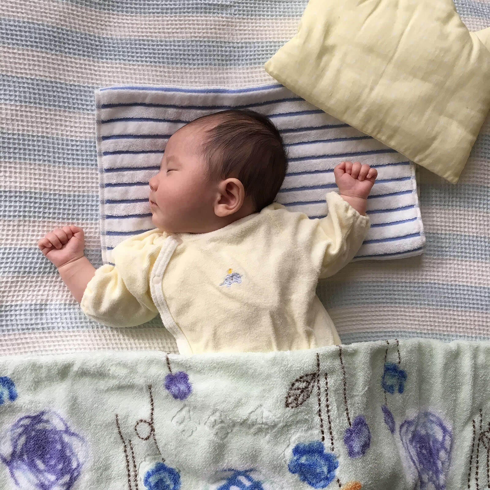 お布団で寝る赤ちゃんの写真